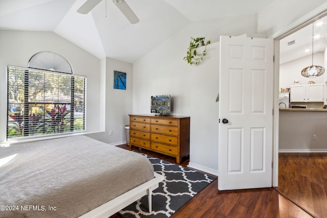 bedroom featuring dark hardwood / wood-style flooring, stainless steel refrigerator, vaulted ceiling, and ceiling fan