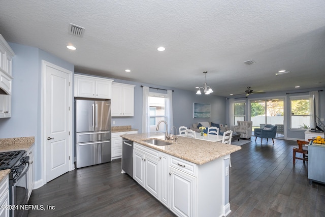 kitchen featuring sink, white cabinetry, stainless steel appliances, and a kitchen island with sink