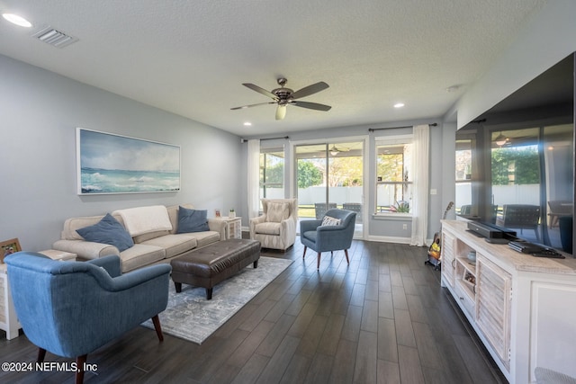 living room featuring a textured ceiling, ceiling fan, and dark wood-type flooring