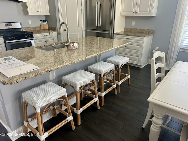 kitchen featuring a breakfast bar, dark hardwood / wood-style floors, white cabinetry, and stainless steel appliances