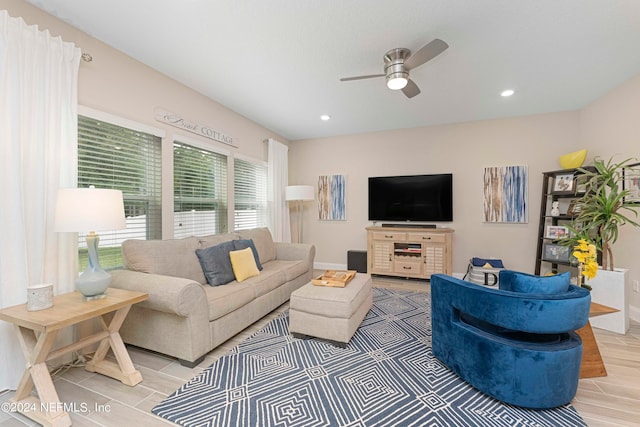 living room featuring light hardwood / wood-style floors, a wealth of natural light, and ceiling fan