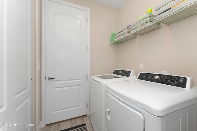 laundry area featuring washer and clothes dryer and light hardwood / wood-style floors