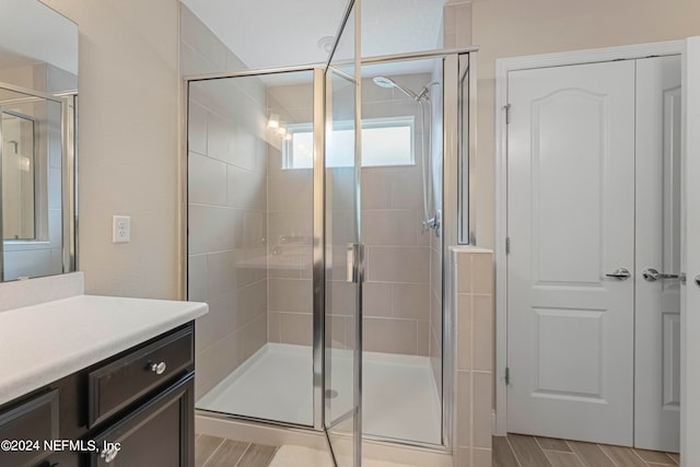 bathroom with vanity, hardwood / wood-style floors, and walk in shower