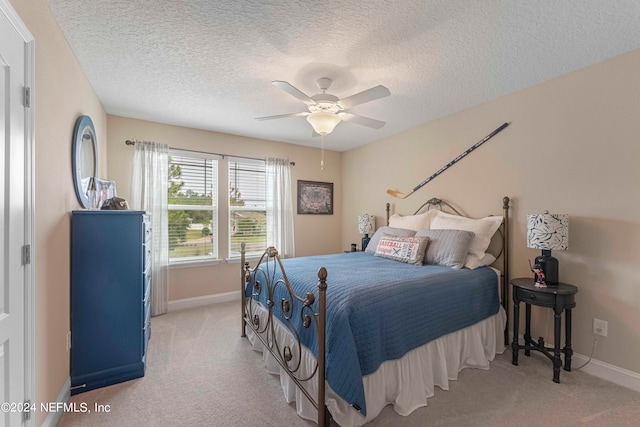 carpeted bedroom with a textured ceiling and ceiling fan