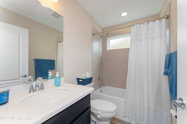 full bathroom featuring toilet, shower / bath combo with shower curtain, and vanity