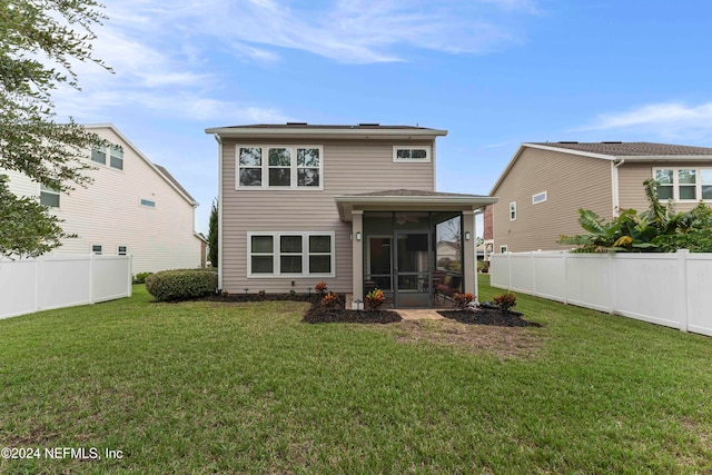 back of property with a yard and a sunroom