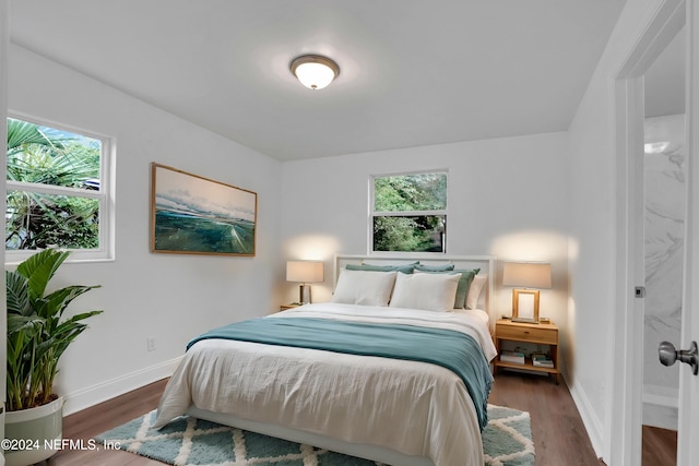 bedroom with multiple windows and dark hardwood / wood-style flooring