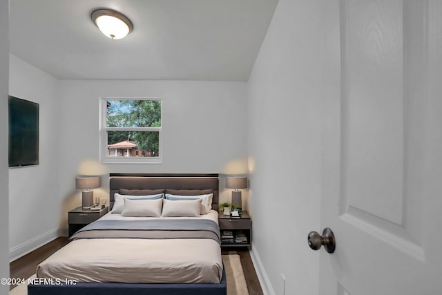 bedroom with dark wood-type flooring