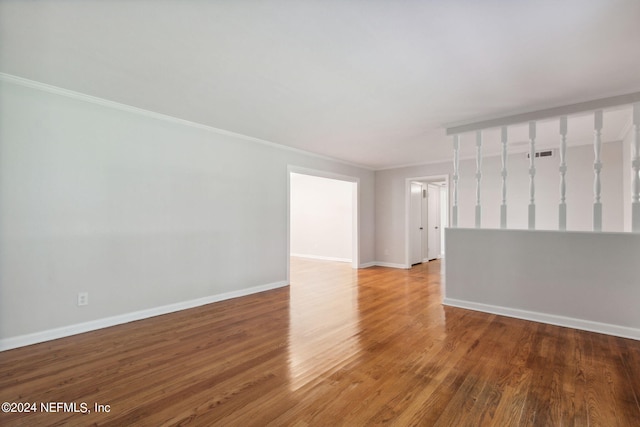 unfurnished room featuring ornamental molding and hardwood / wood-style flooring