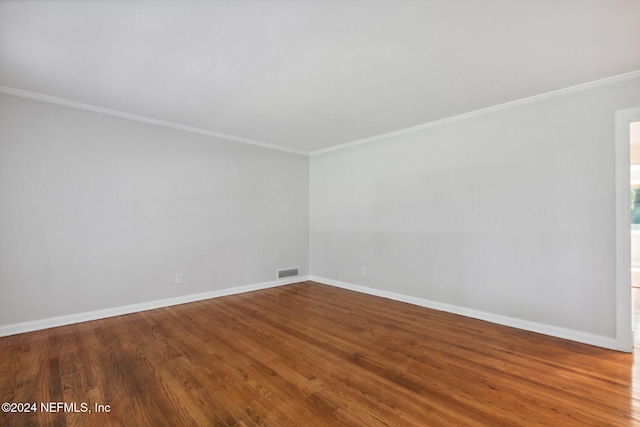 unfurnished room featuring wood-type flooring and ornamental molding