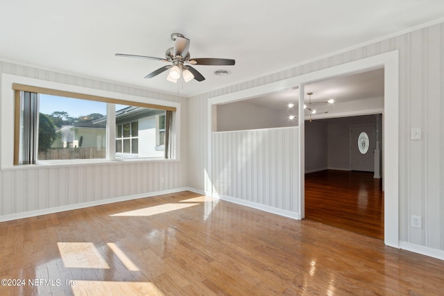 unfurnished room with crown molding, wood-type flooring, and ceiling fan