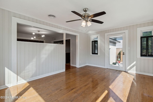 empty room featuring hardwood / wood-style floors and ceiling fan with notable chandelier