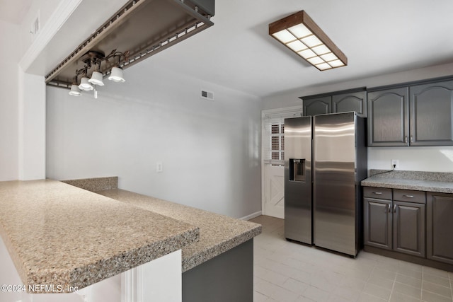 kitchen featuring kitchen peninsula and stainless steel fridge