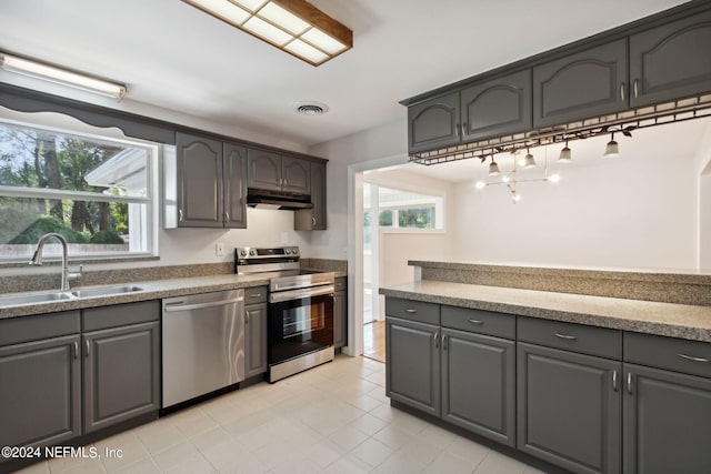 kitchen with appliances with stainless steel finishes, sink, and light tile patterned floors