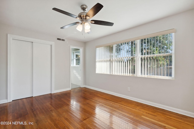 unfurnished bedroom with wood-type flooring, a closet, and ceiling fan