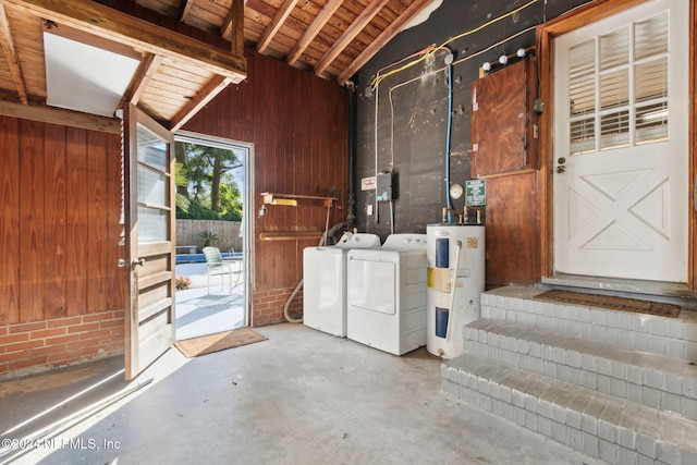 interior space with water heater, washer and clothes dryer, wooden ceiling, and wood walls