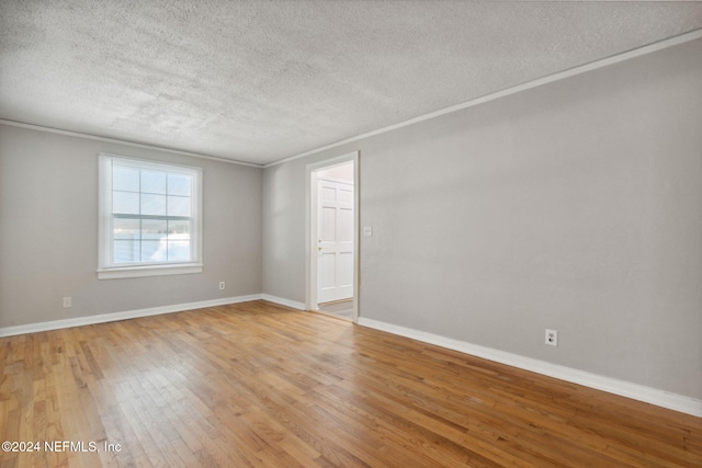 unfurnished room featuring light hardwood / wood-style floors, crown molding, and a textured ceiling