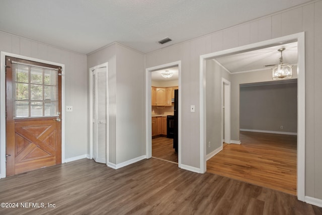 interior space featuring dark wood-type flooring, crown molding, and a textured ceiling