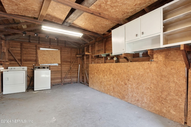 garage with wooden walls and separate washer and dryer