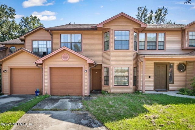 view of front of house with a garage and a front lawn