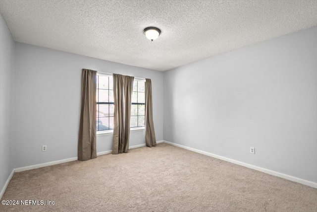 carpeted empty room with a textured ceiling