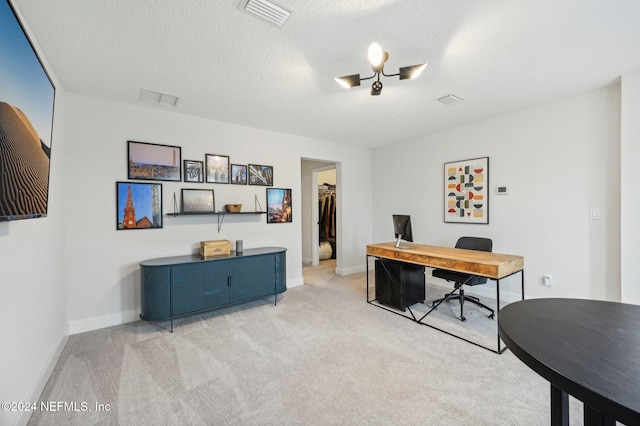 carpeted home office with a textured ceiling