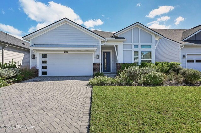 view of front of house featuring a front lawn and a garage