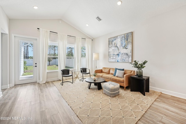 living room featuring light hardwood / wood-style flooring and lofted ceiling