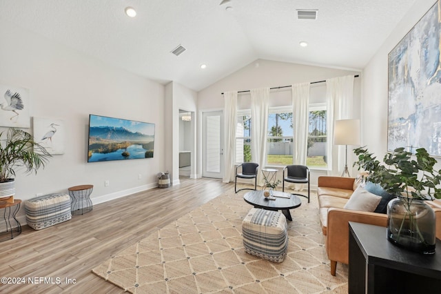 living room featuring lofted ceiling and light wood-type flooring