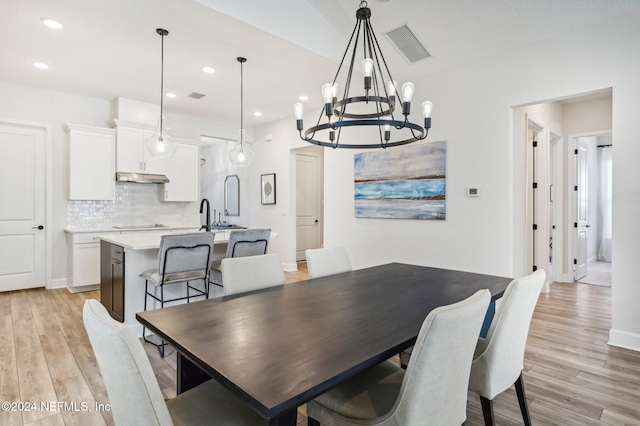 dining room featuring light hardwood / wood-style flooring and an inviting chandelier