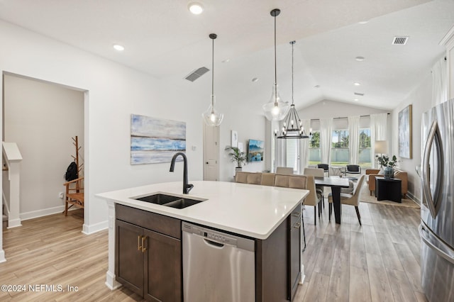 kitchen featuring appliances with stainless steel finishes, sink, an island with sink, light hardwood / wood-style floors, and lofted ceiling