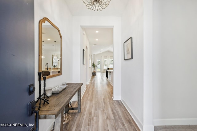 hallway featuring vaulted ceiling and light hardwood / wood-style floors