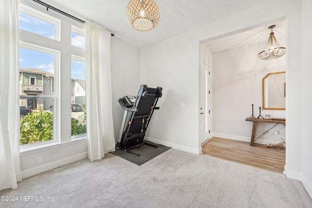 exercise area with a chandelier and carpet floors