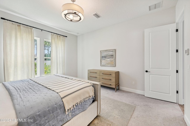 bedroom featuring light carpet and a textured ceiling