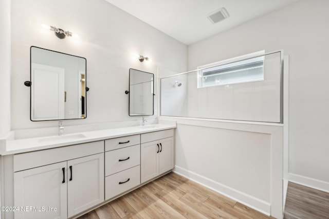 bathroom with vanity, walk in shower, and hardwood / wood-style floors