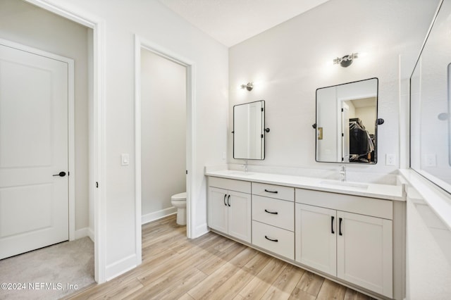 bathroom with vanity, toilet, and hardwood / wood-style flooring