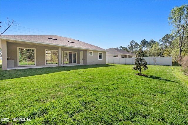 rear view of house with a patio area and a yard