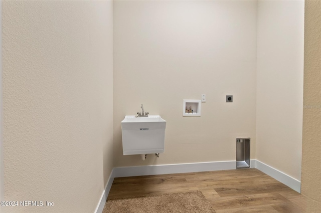 clothes washing area featuring hookup for a washing machine, electric dryer hookup, light hardwood / wood-style flooring, and sink