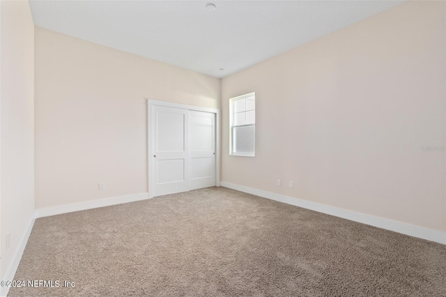 unfurnished bedroom featuring carpet and a closet