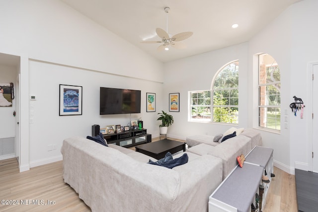 living room featuring high vaulted ceiling, light hardwood / wood-style floors, and ceiling fan