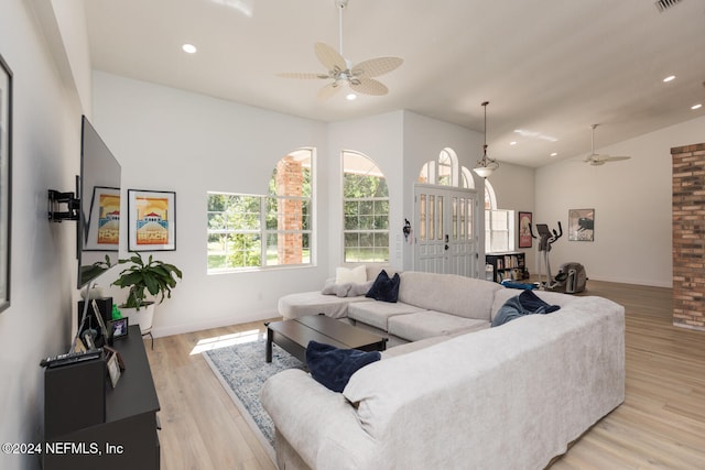 living room with light hardwood / wood-style floors, lofted ceiling, and ceiling fan