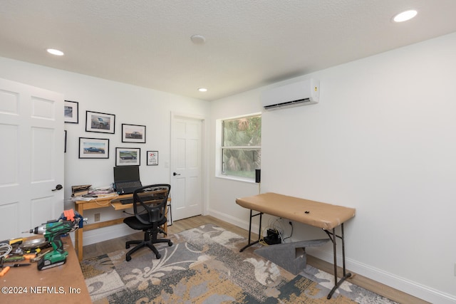 office area with light hardwood / wood-style floors and a wall unit AC