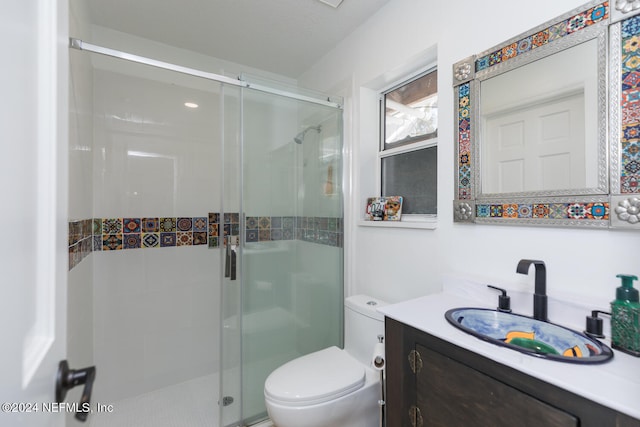 bathroom featuring vanity, a textured ceiling, toilet, and walk in shower