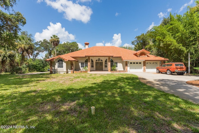 mediterranean / spanish house featuring a front lawn and a garage