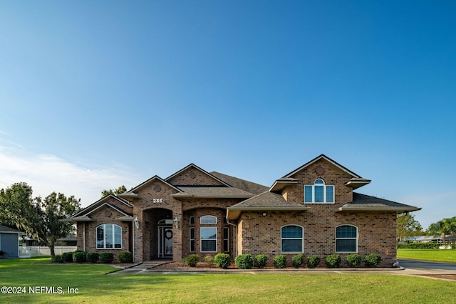 235 Crystal Cove Dr, Palatka, FL 32177 - view of front of house featuring a front yard, brick siding, and roof with shingles