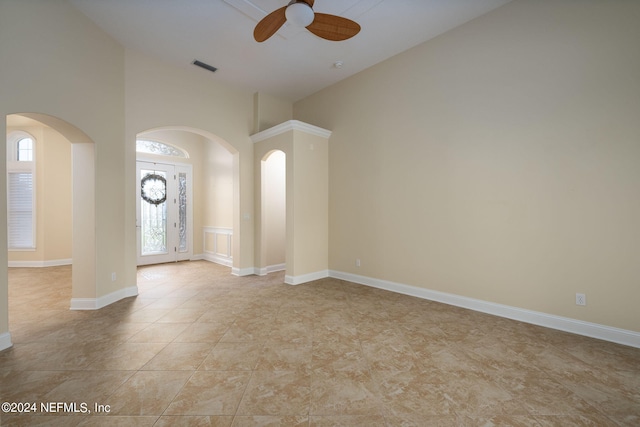 unfurnished room with ceiling fan and high vaulted ceiling