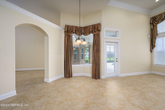 235 Crystal Cove Dr, Palatka, FL 32177 - unfurnished dining area with crown molding, baseboards, arched walkways, and a chandelier