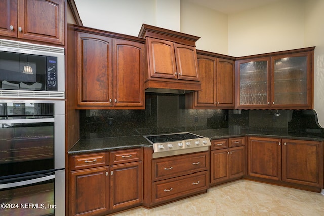 kitchen featuring dark stone countertops, backsplash, stainless steel appliances, and custom range hood