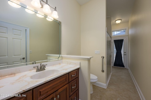 bathroom with walk in shower, vanity, toilet, and tile patterned flooring