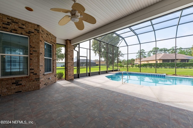 view of pool featuring a patio, ceiling fan, a lanai, and a lawn